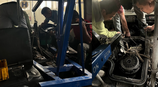 Photograph showing the diesel engine being carefully lifted out of the Eicher bus